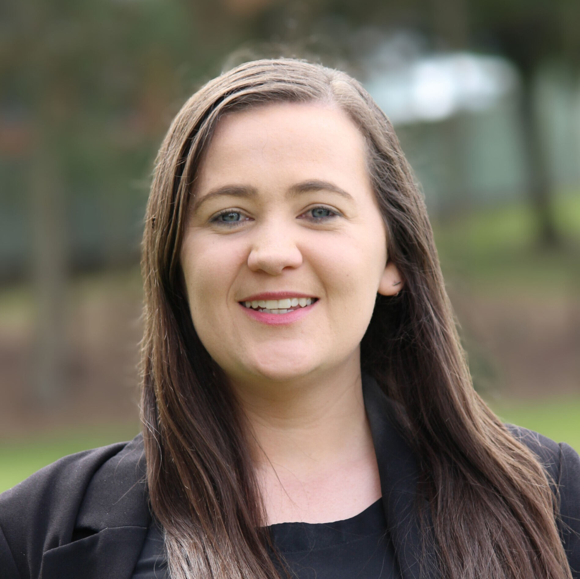 Professional headshot of psychologist Melanie Grabham, EMDR-accredited practitioner, photographed outdoors in Newcastle NSW.