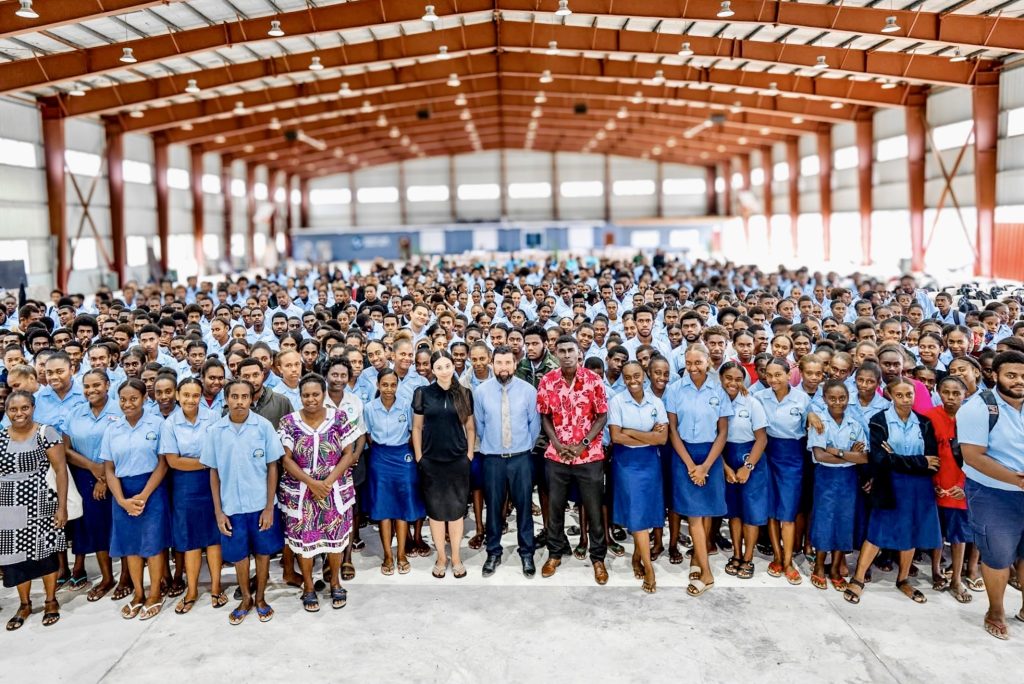 Large group of students gathered in a school hall in Vanuatu for a mental health education session focused on wellbeing and coping strategies